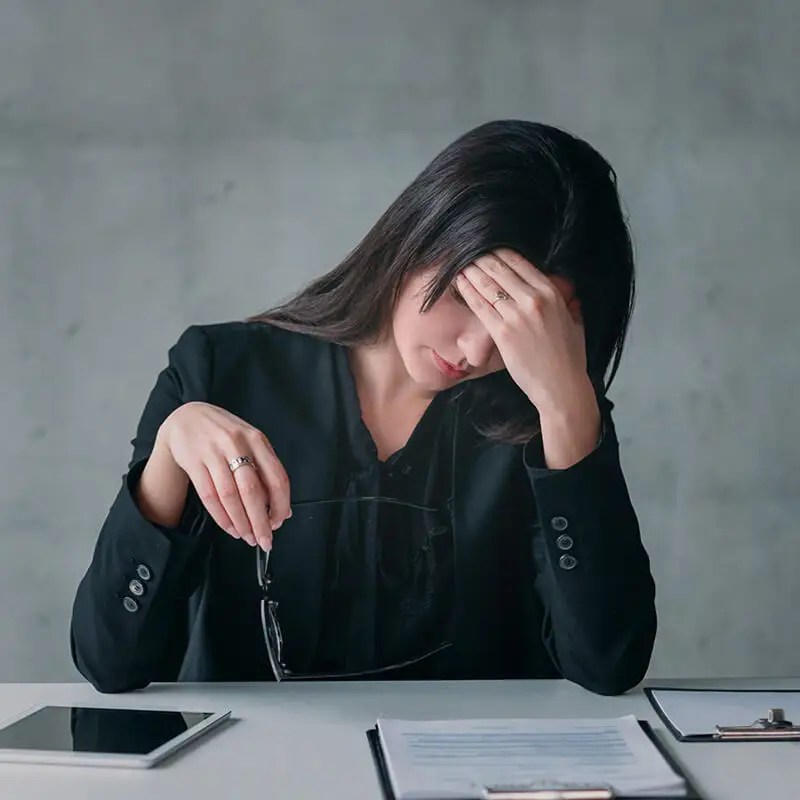 Clinician sitting at desk appearing overwhelmed representing professional stress and need for supervision support