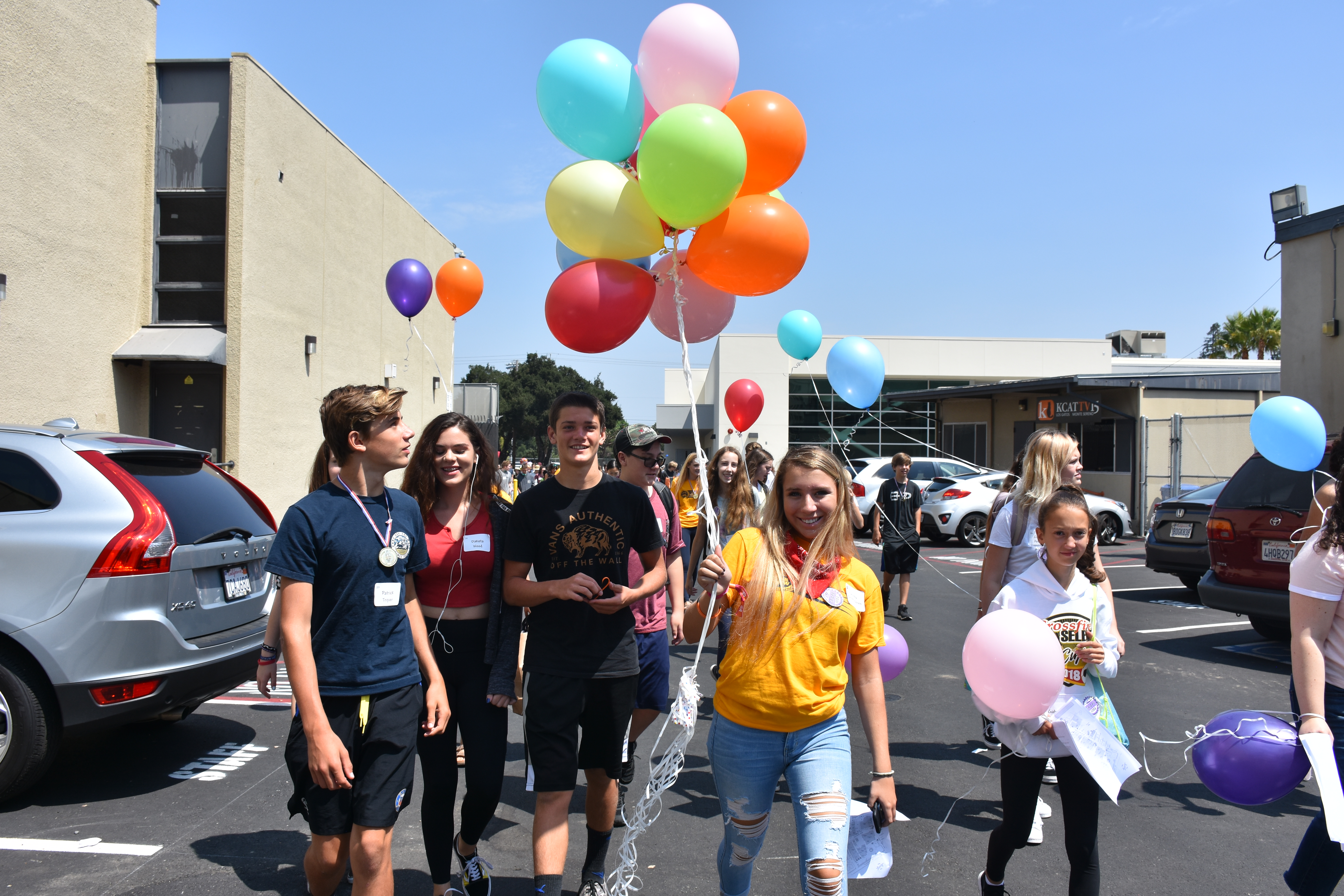 Freshmen and their Link Crew leader tour around the Small Gym holding balloons