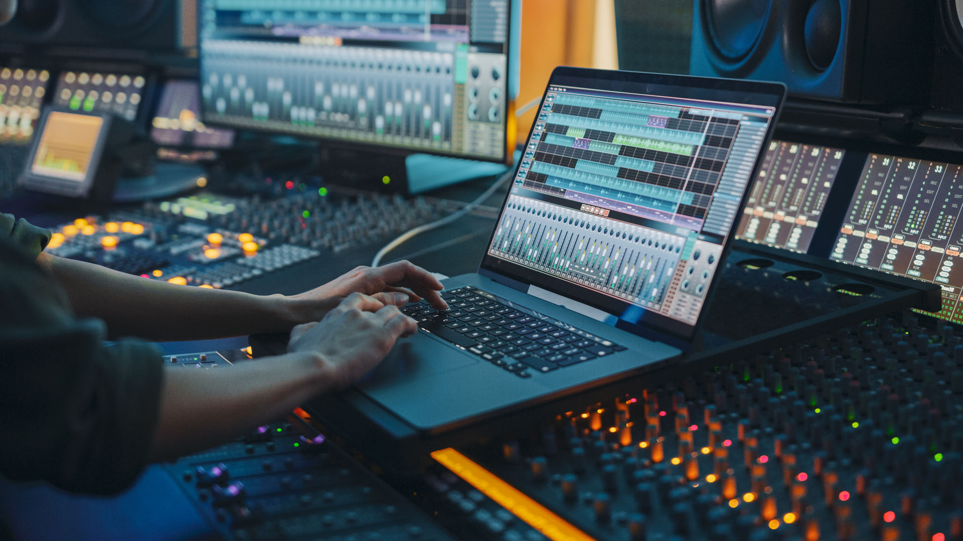 Modern Music Record Studio Control Desk with Laptop Screen Showing User Interface of Digital Audio Workstation Software. Equalizer, Mixer and Professional Equipment. Faders, Sliders. Record. Close-up