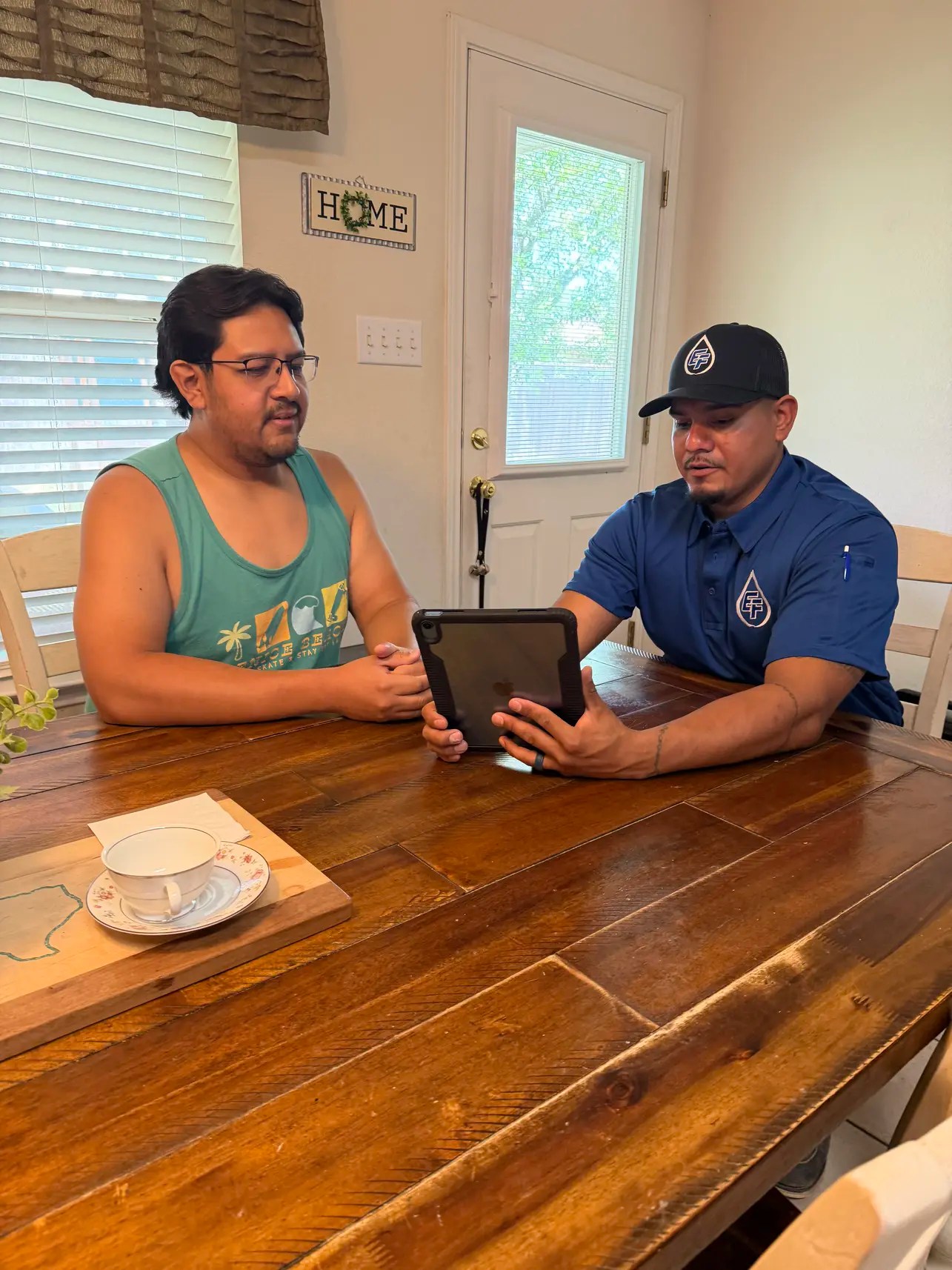 Julio Rangel walking an Austin customer through plumbing service estimates and FAQs on a tablet