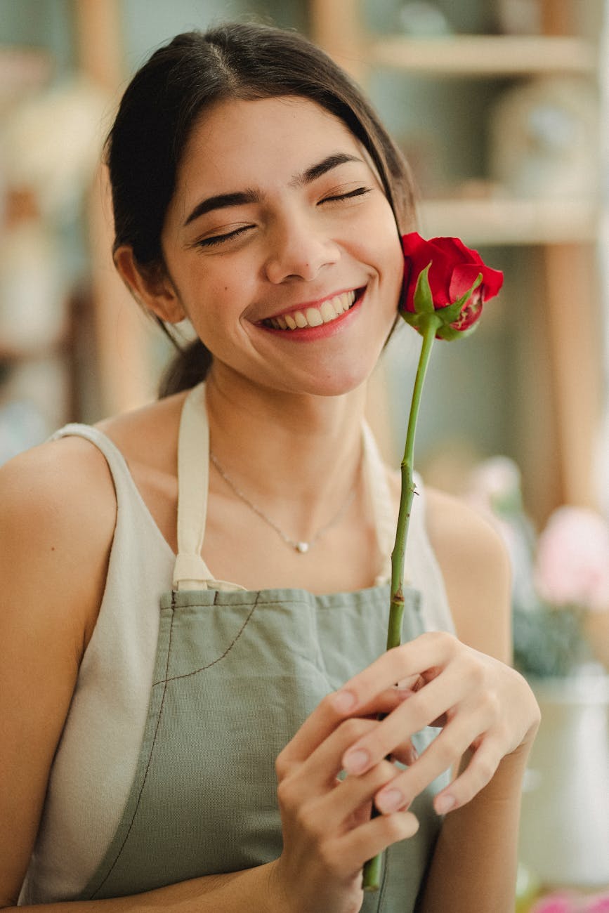 florist holding flower and smiling in shop