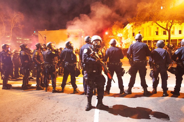 Agentes de policía con equipo antidisturbios se enfrentan a unos 500 manifestantes en la calle Broadway en Oakland el 24 de noviembre. Foto Santiago Mejia