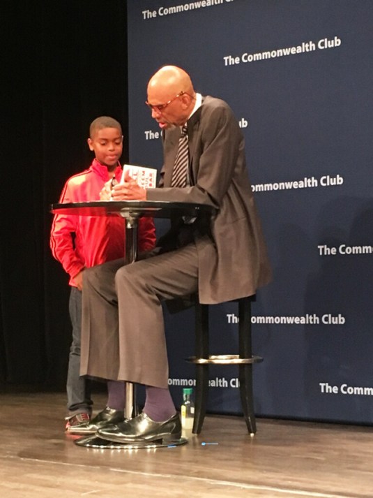 Kareem Abdul-Jabbar (right) signs a copy of his book for a young fan on Aug. 30 in San Francisco. Photo Alejandro Galicia-Díaz