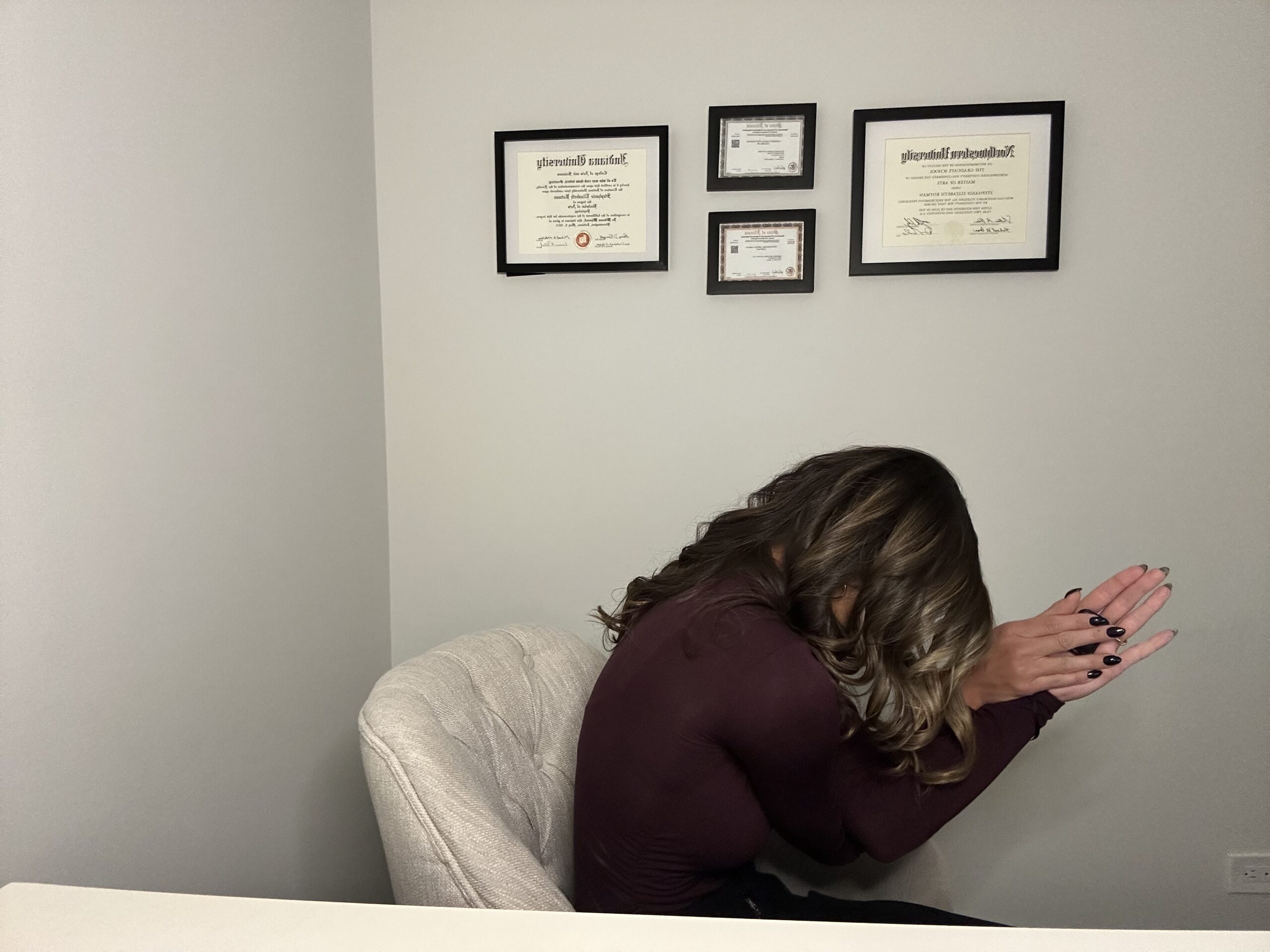 Woman practicing Eagle Armed Cat pose at her desk, a desk yoga stretch for stress relief and increased productivity.