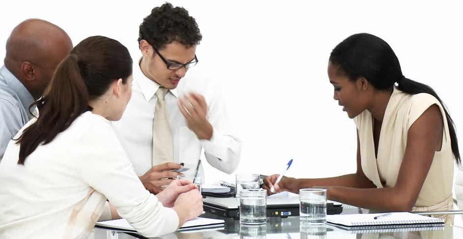 A black woman consulting with a diverse group of 3 sitting at a table