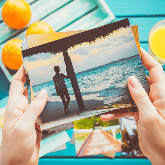 Woman looking at photos in her hands. Top view.