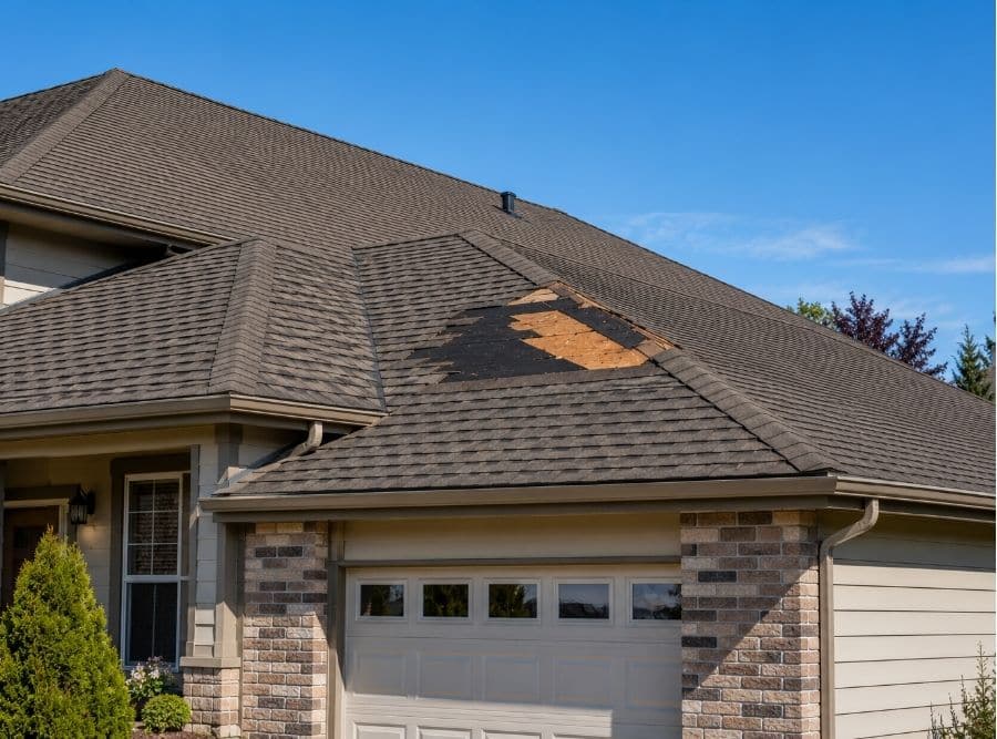 Missing asphalt shingles exposing roof underlayment on a residential home in Nampa, Idaho after a windstorm.