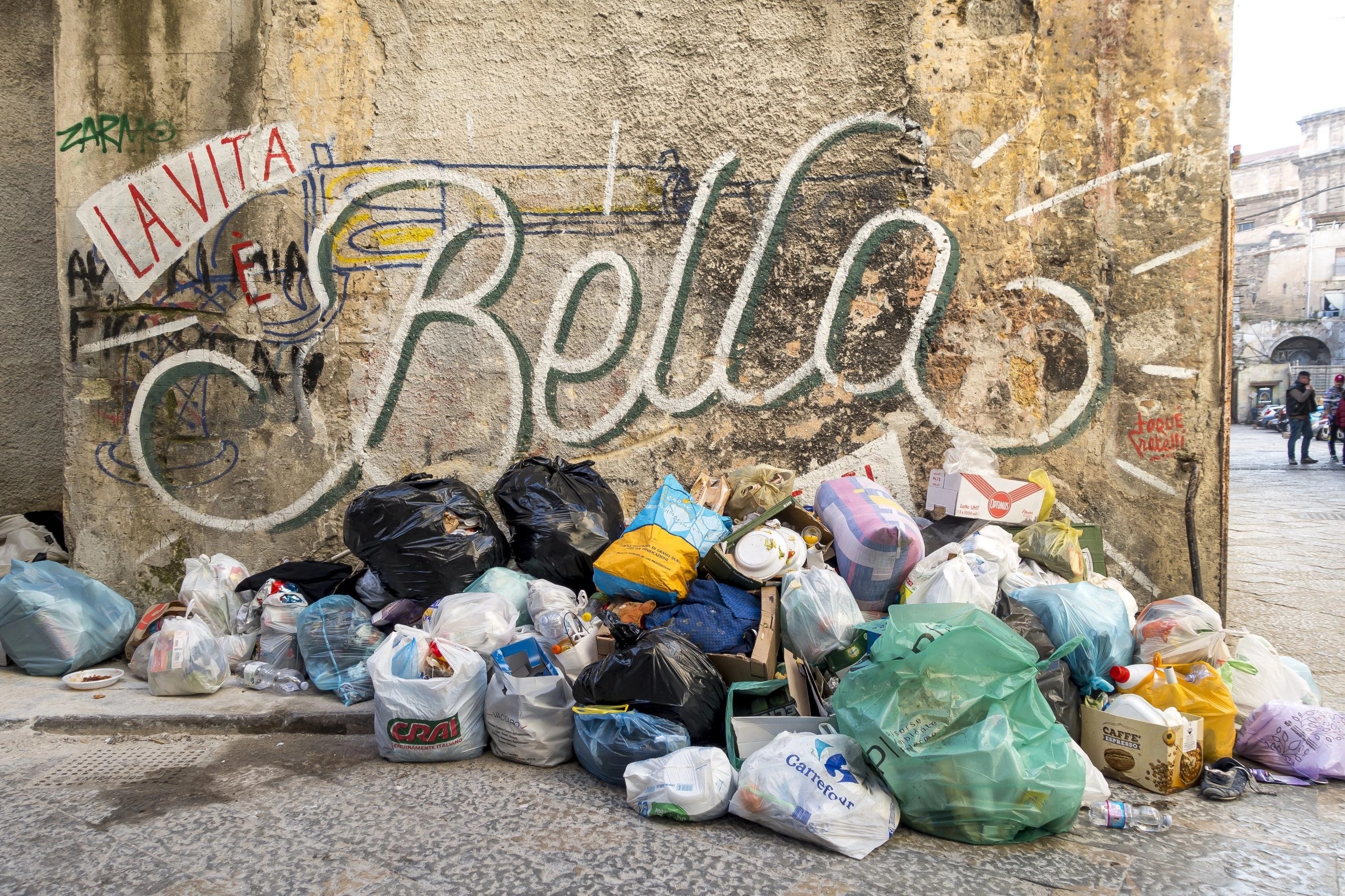 Contradiction depicted by a pile of garbage in front of the words, "La Vita e Bella"