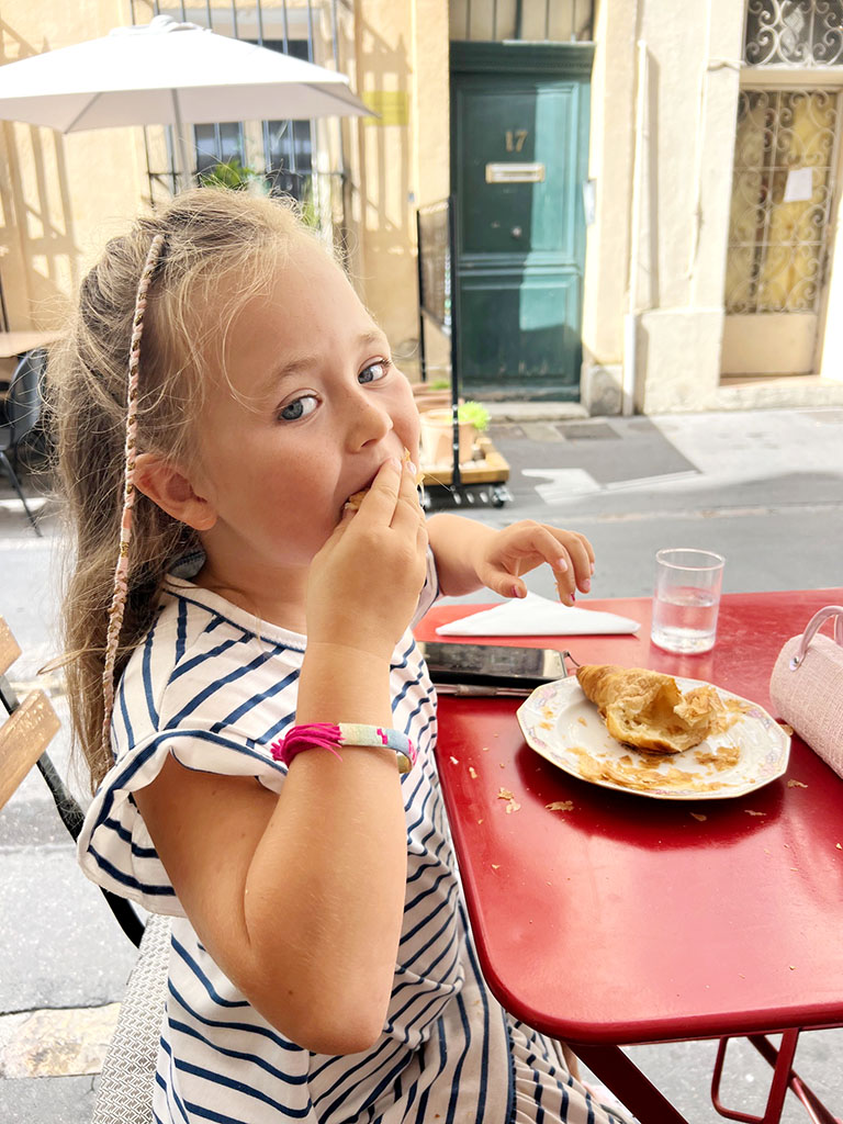 Nellie eating a croissant in Aix-en-Provence