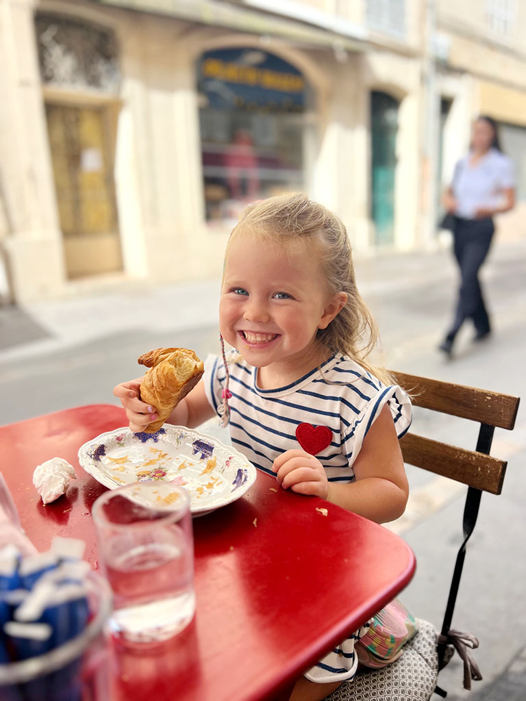 Lottie eating a croissant in Aix-en-Provence