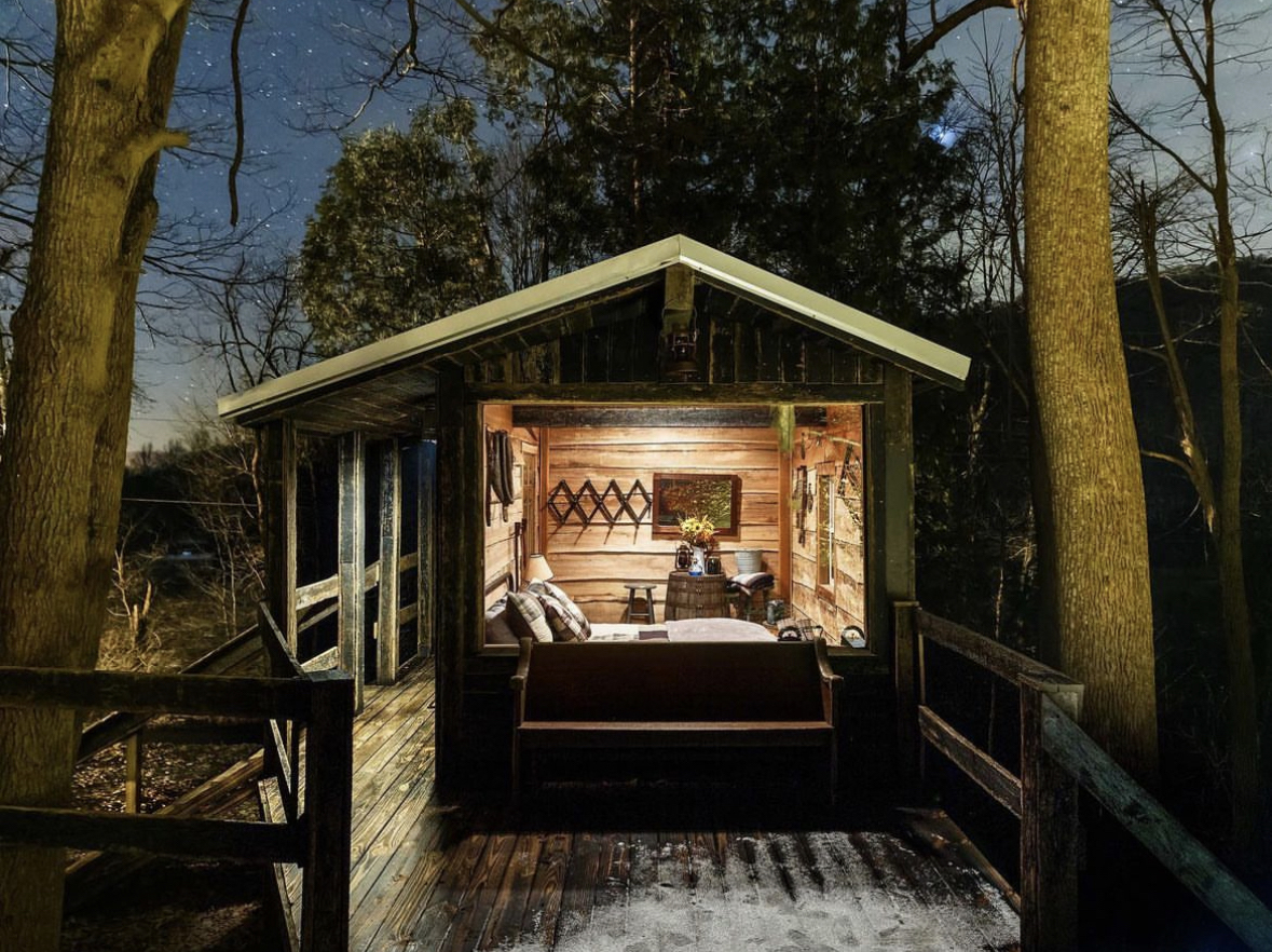 Glass-front cabin deck at night in the woods