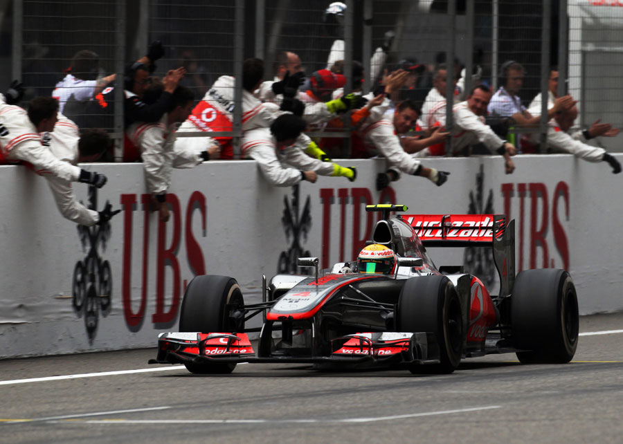 Lewis Hamilton Passes His Celebrating Pit Crew As He Crosses