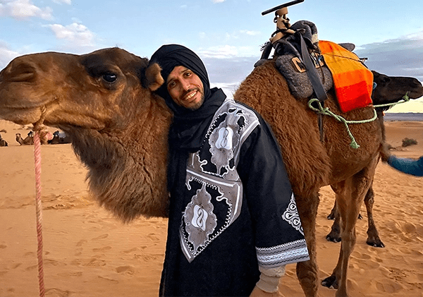 Hamid hug a camel in the desert