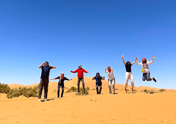 Hamid with passengers jumping in the desert