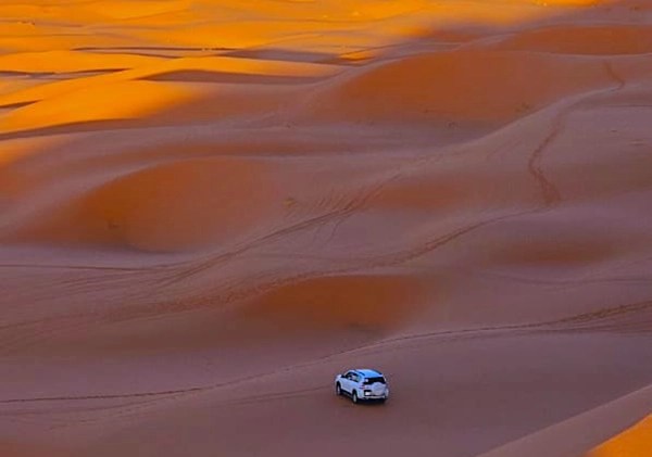 Musti, the adventure operator in the middle of dunes with his 4x4