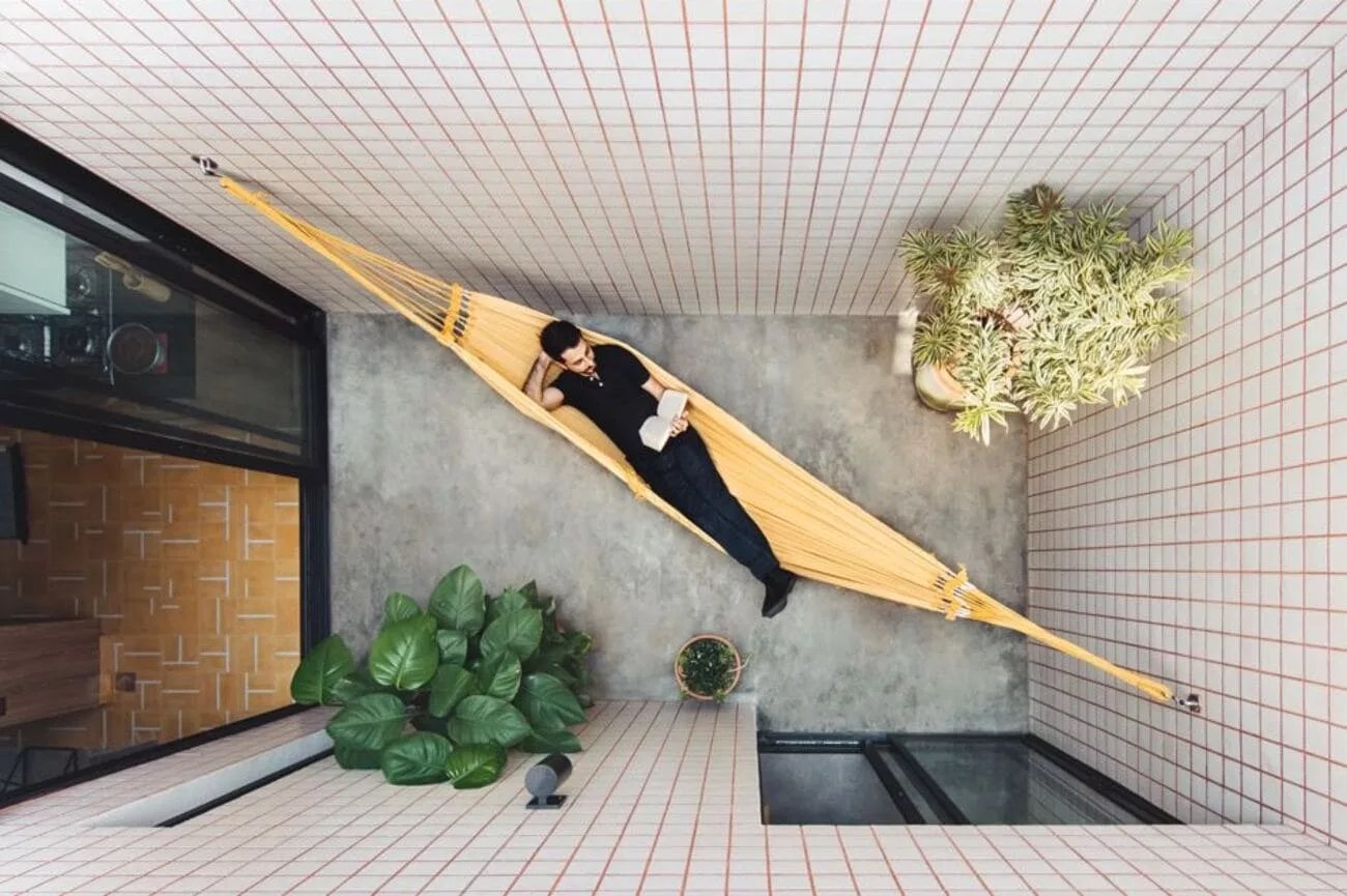 Além de valorizar o projeto, a abertura no teto é um ‘respiro’ entre os ambientes da casa | Projeto do escritório Rawi Arquitetura + Design | Foto: Juliana Deeke