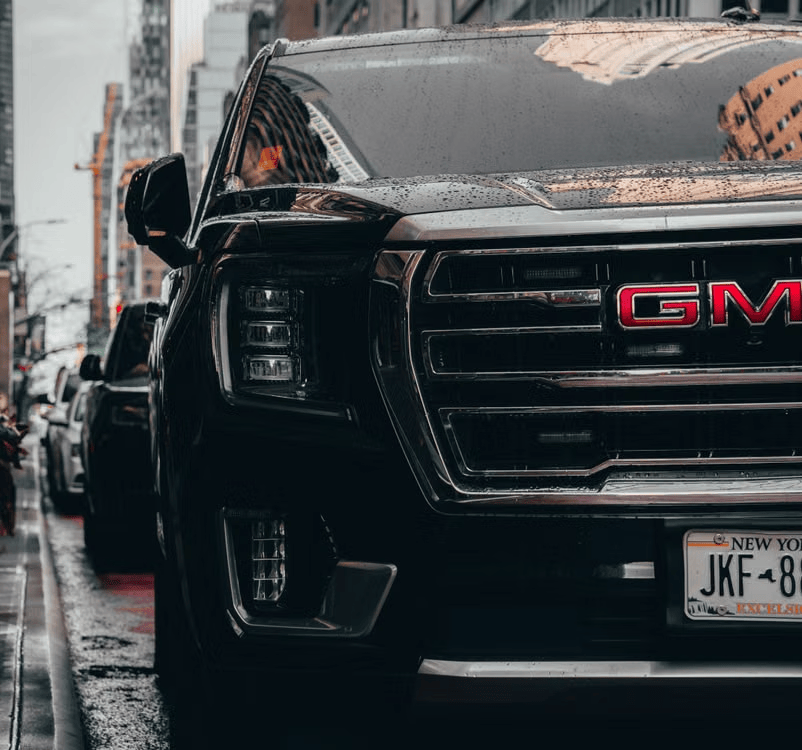 GMC pickup truck parked on a city street, representing GM’s lineup competing with rising Chinese imports