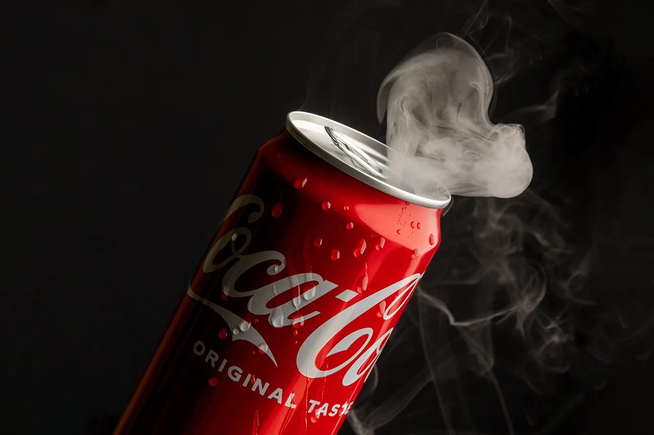 Coca-Cola limenka sa parom i kapljicama kondenzacije na crnoj pozadini, studijska produkt fotografija
