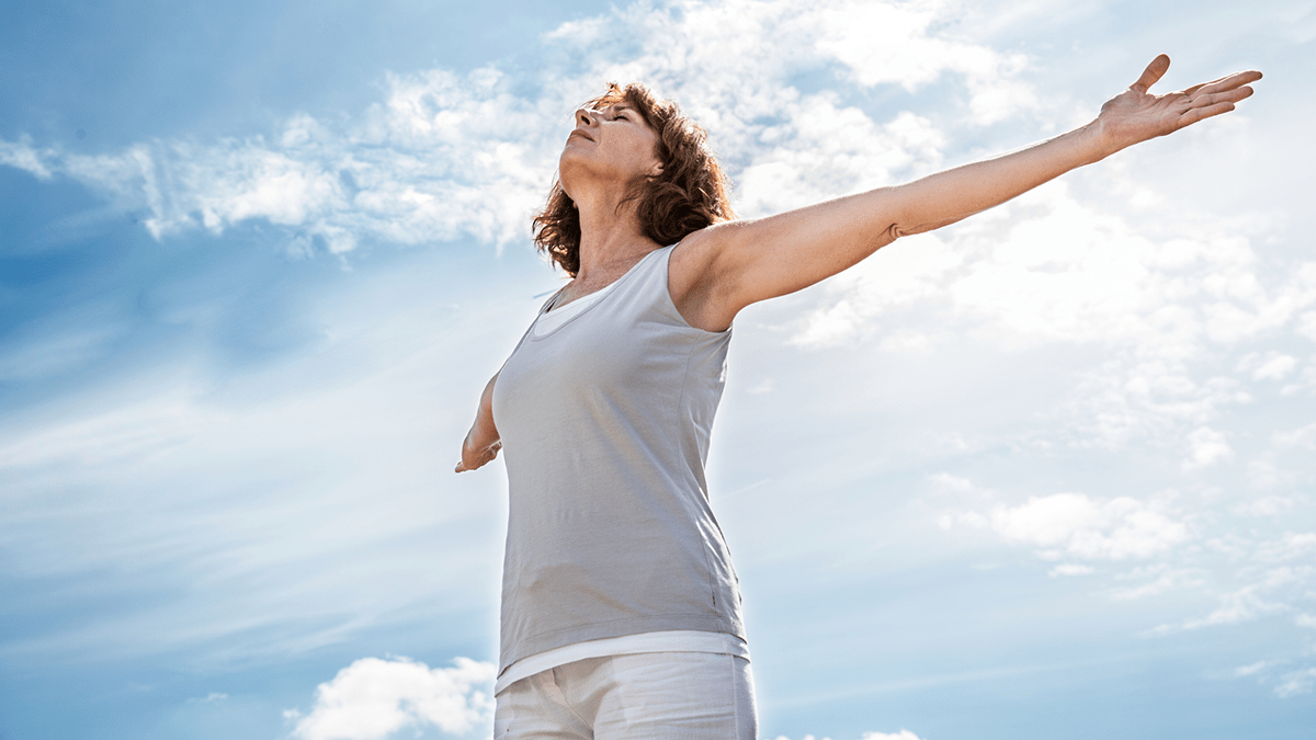 Exercise, light exercise, outdoor stretching, morning routine, wellness movement, women’s fitness, breathing exercises, energizing morning, open arms pose, body awareness, outdoor workout, healthy lifestyle, holistic fitness, gentle exercise, sky background, self-care activity