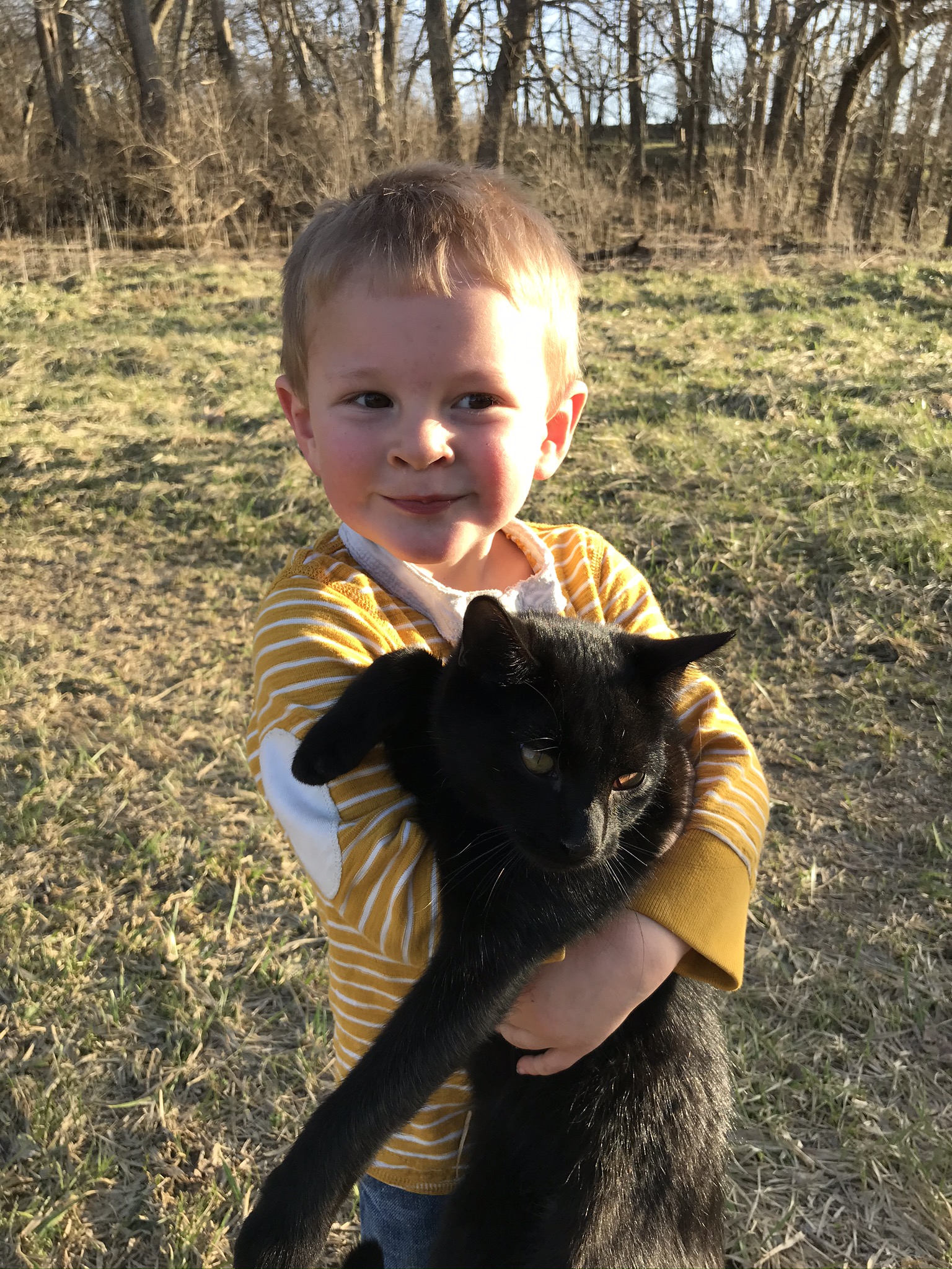 boy holding a black cat