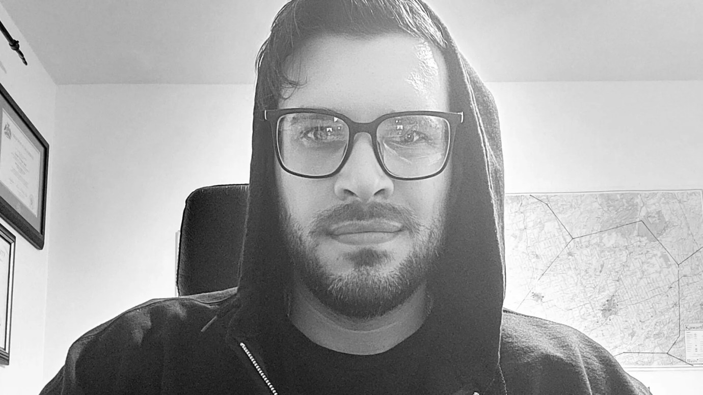 A black and white photograph of Keith from USB Escape in a hoodie and glasses.