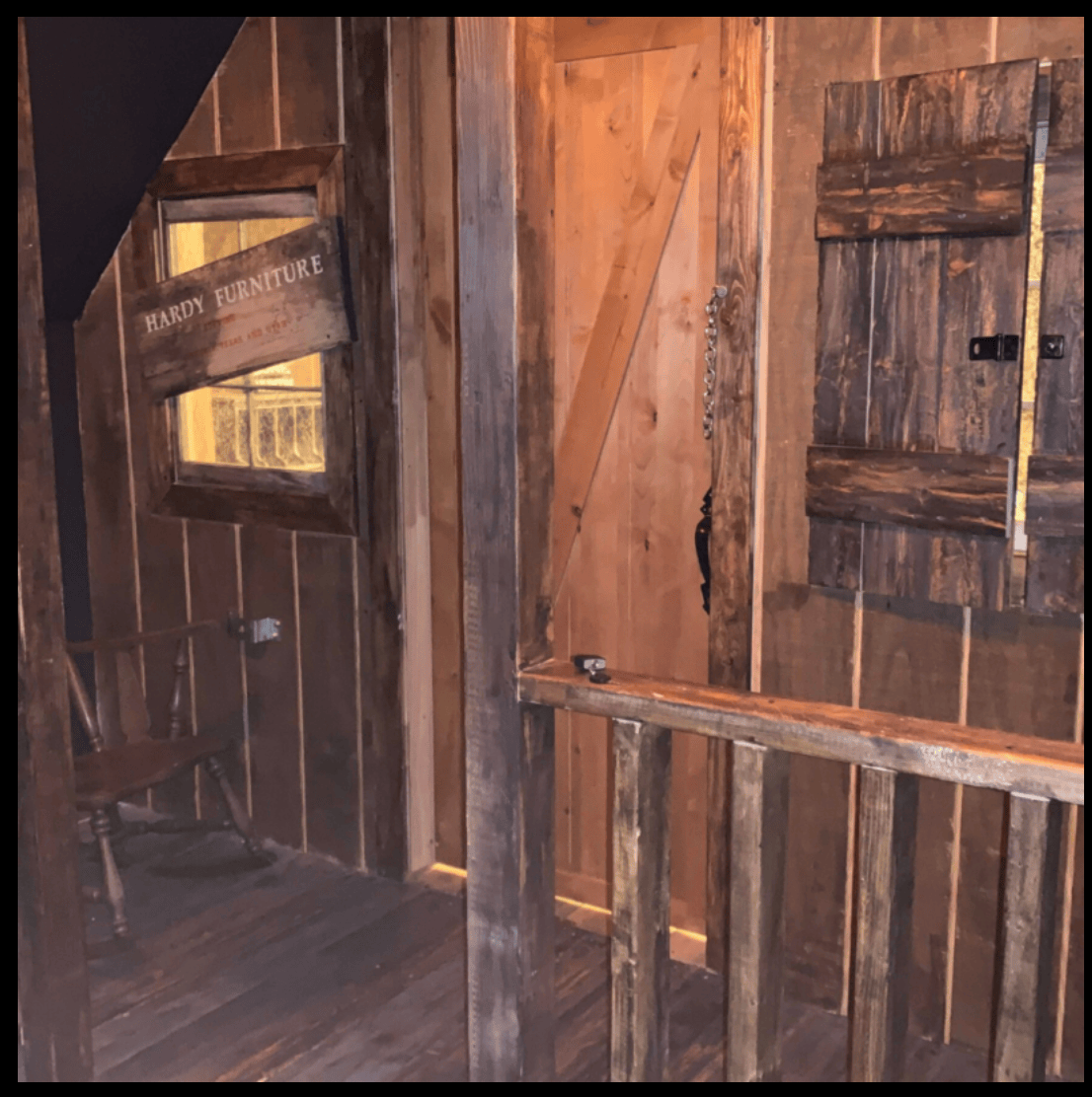 Rustic wooden escape room interior with Hardy Furniture sign.