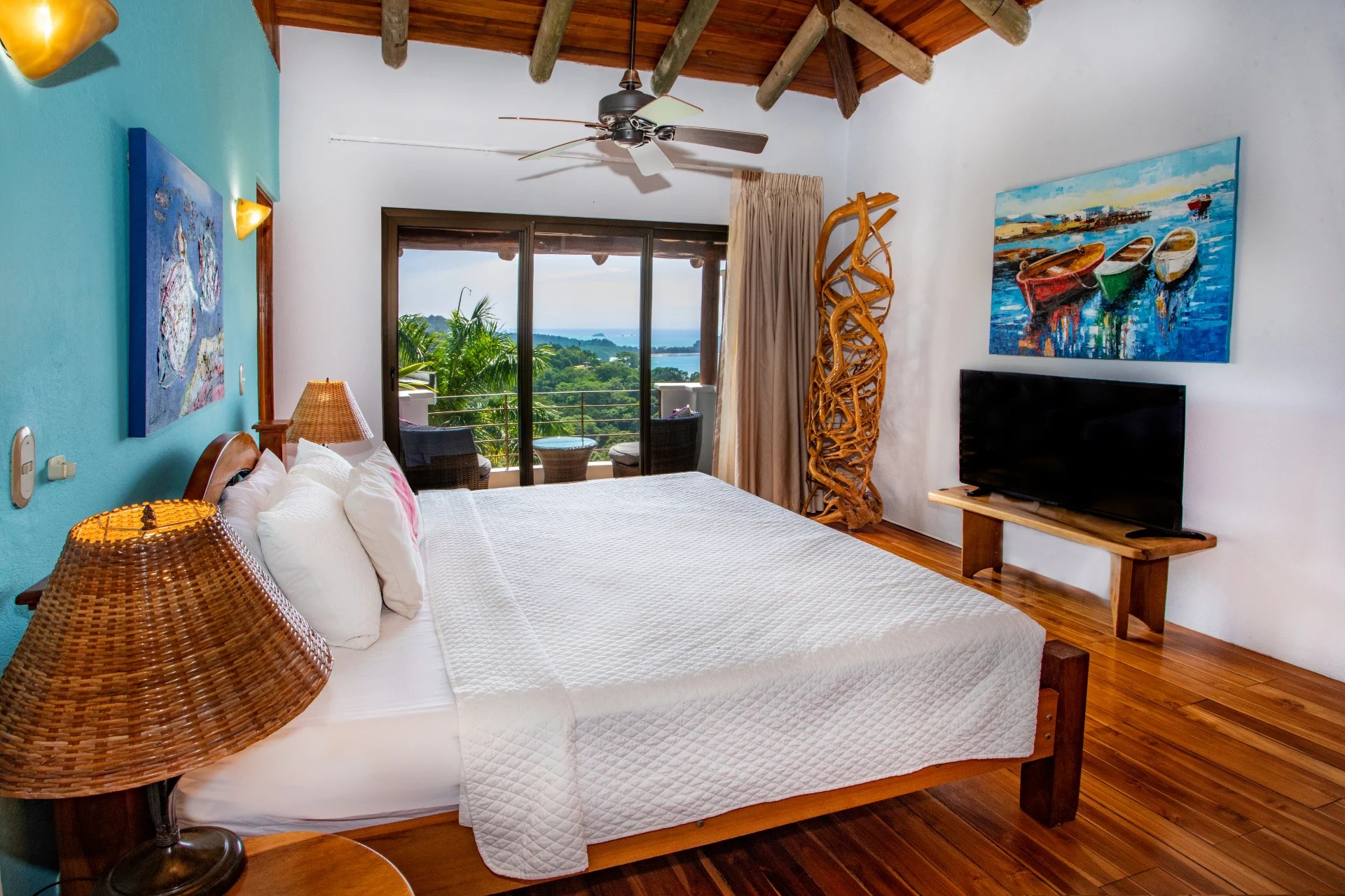 Bedroom with wooden floors, ocean view, sliding glass doors, and private terrace