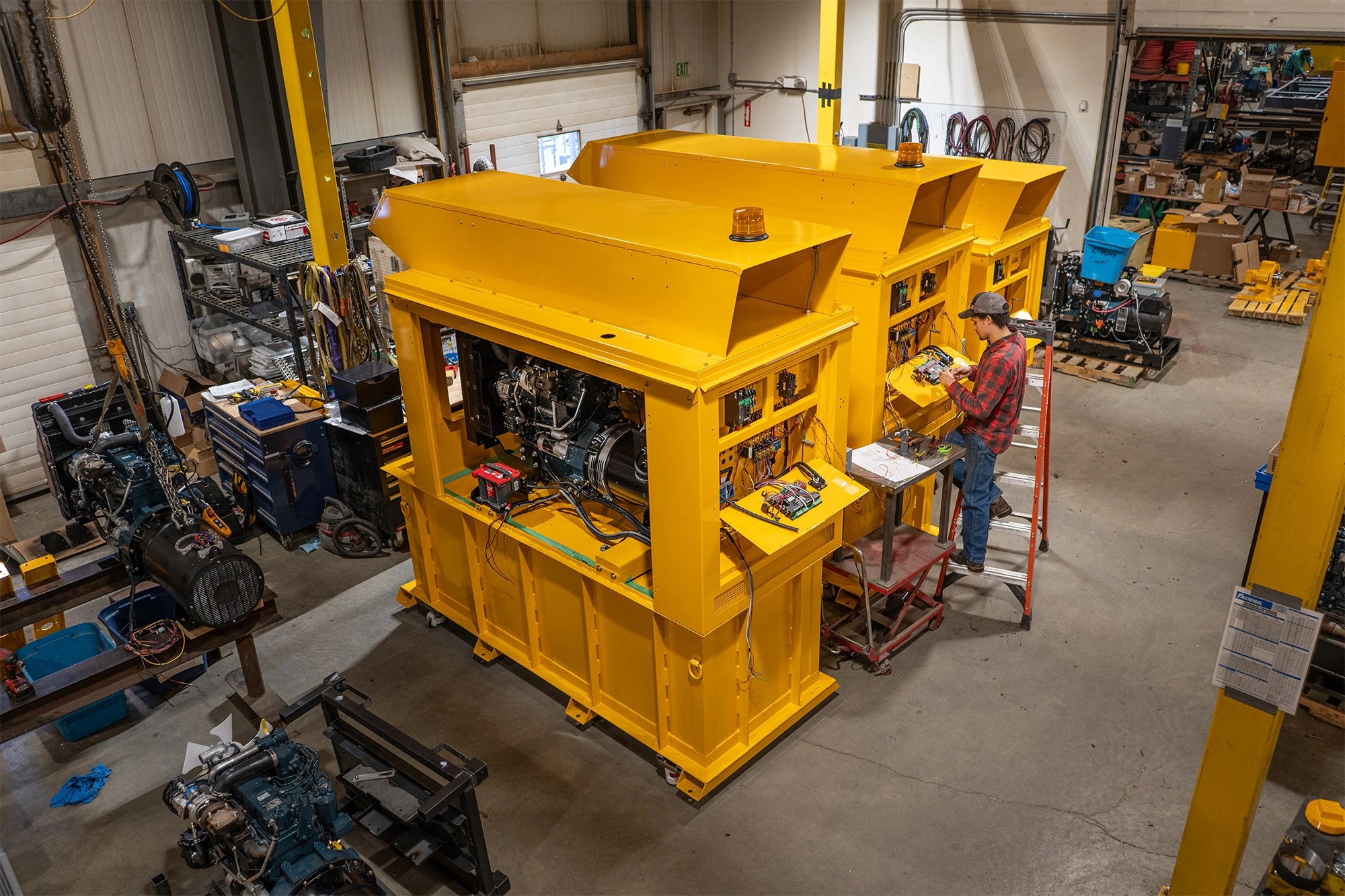 A technician wiring the control panel on a large ESI generator.