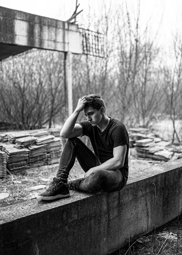 Uomo preoccupato seduto sul muretto