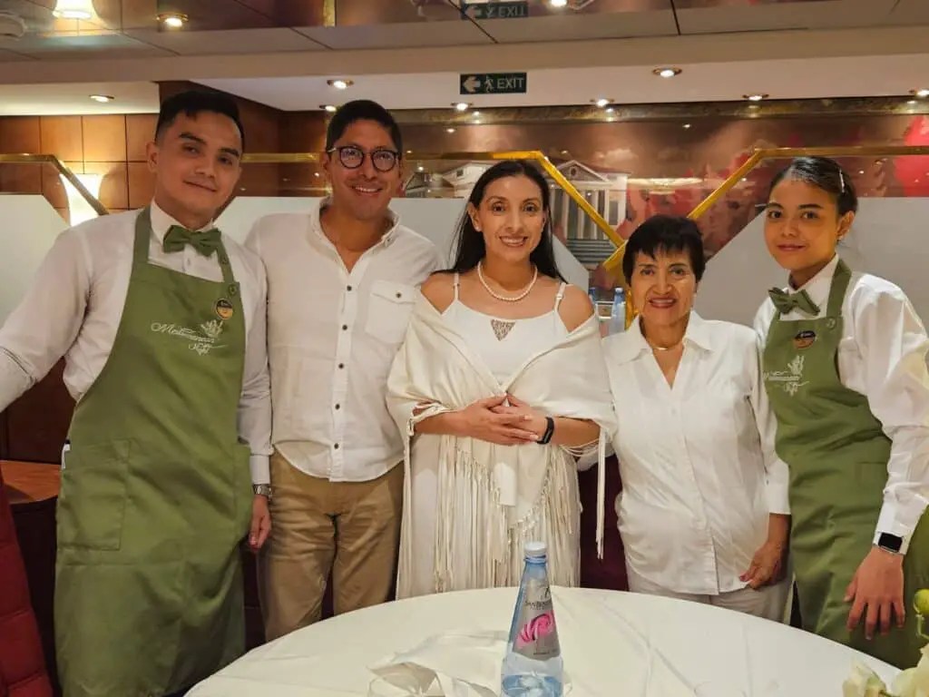 Meseros del comedor principal del crucero MSC poesia junto a Esteban Luje, su esposa y su suegra.