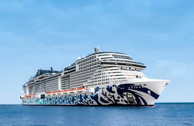 Vista lateral del crucero MSC Euribia navegando sobre el océano, destacando su enorme tamaño y el colorido diseño artístico pintado en el casco del barco.