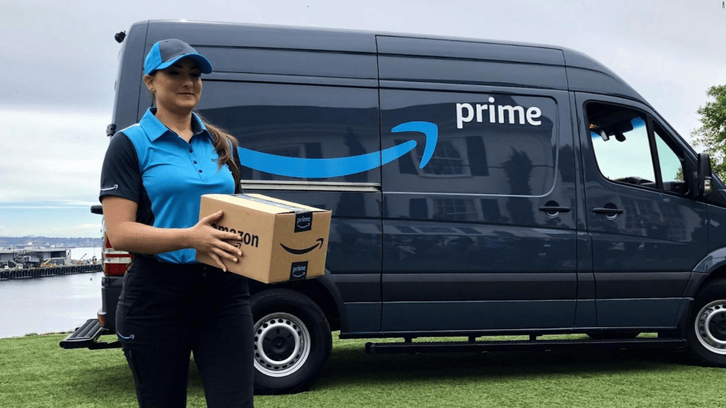 Repartidora de Amazon Prime entregando un paquete puerta a puerta frente a una camioneta de reparto de Amazon