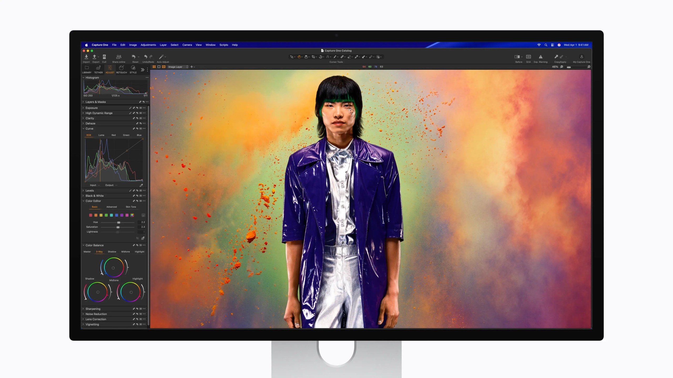 A vibrant digital portrait of a person wearing a shiny purple jacket and silver outfit, set against a colorful background with splashes of color, displayed on a computer monitor running Capture One software.