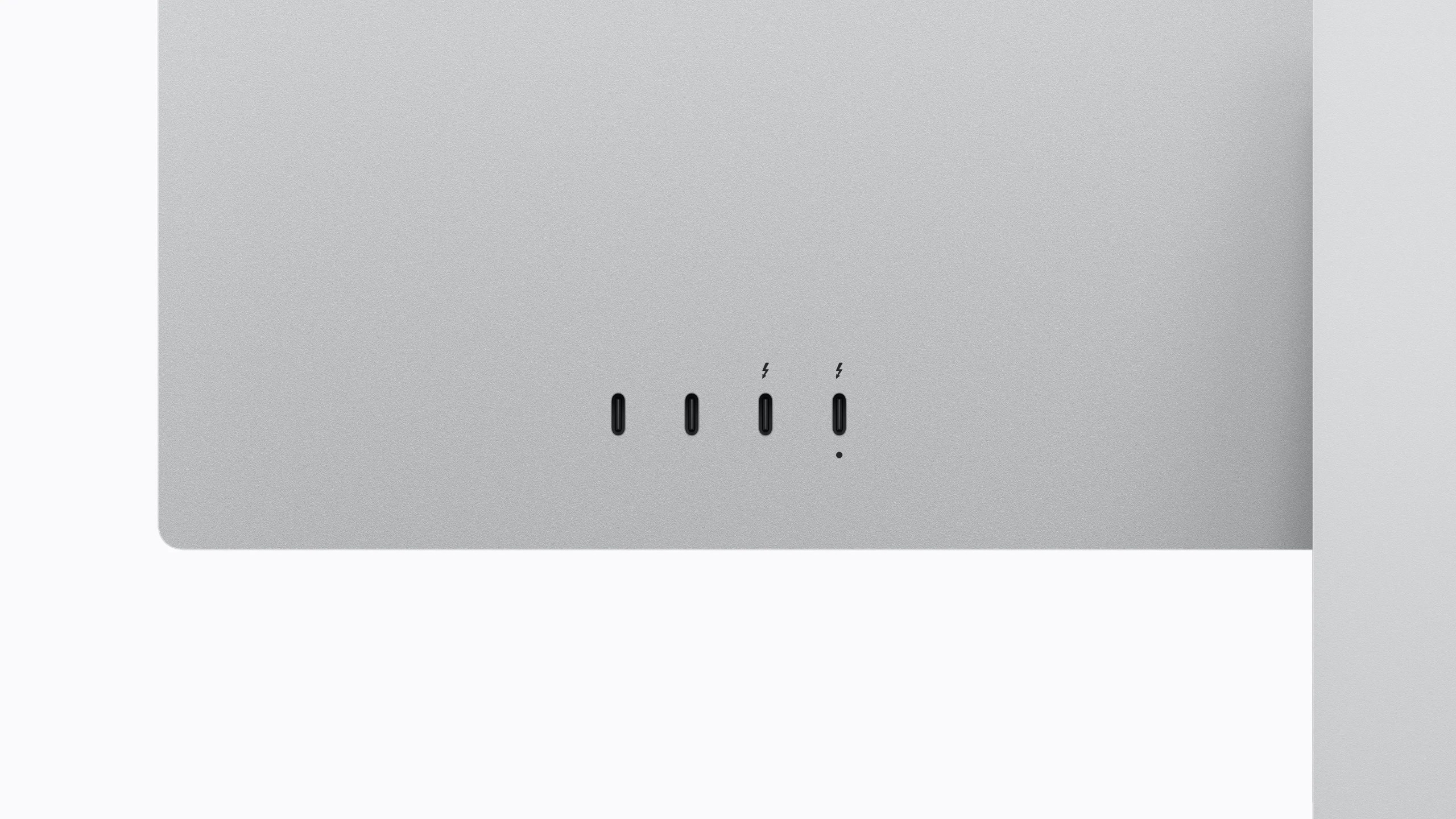 Close-up of a metallic surface featuring multiple ports, including three Thunderbolt icons and one light indicator.