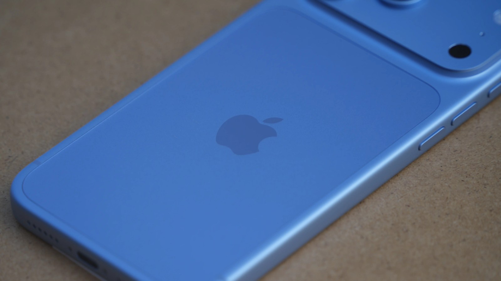 Close-up of a blue smartphone featuring the Apple logo on the back.