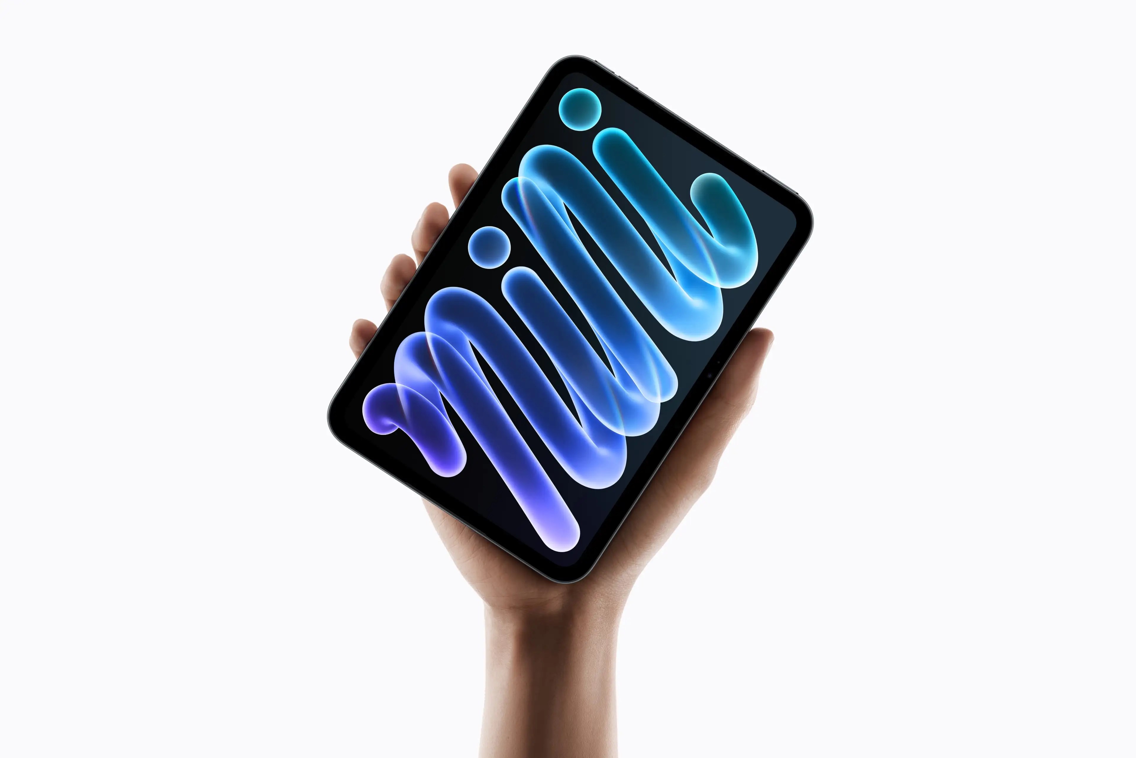 A person's hand holds a small tablet displaying a vibrant abstract blue spiral wallpaper.