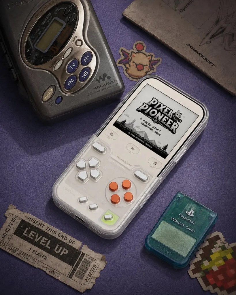 A white handheld gaming console displaying Pixel Pioneer sits on a purple surface surrounded by retro gaming accessories.
