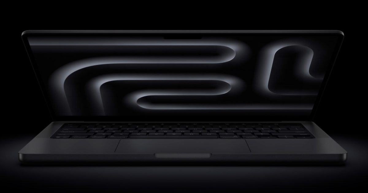 A space black MacBook Pro laptop is slightly open, displaying a dark, abstract wavy pattern on its screen.