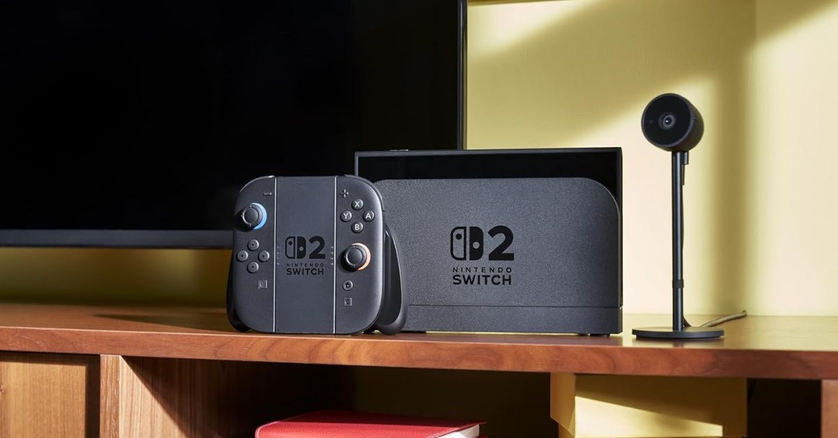 A mock-up of a Nintendo Switch 2 console, controller, and camera accessory sitting on a wooden shelf.