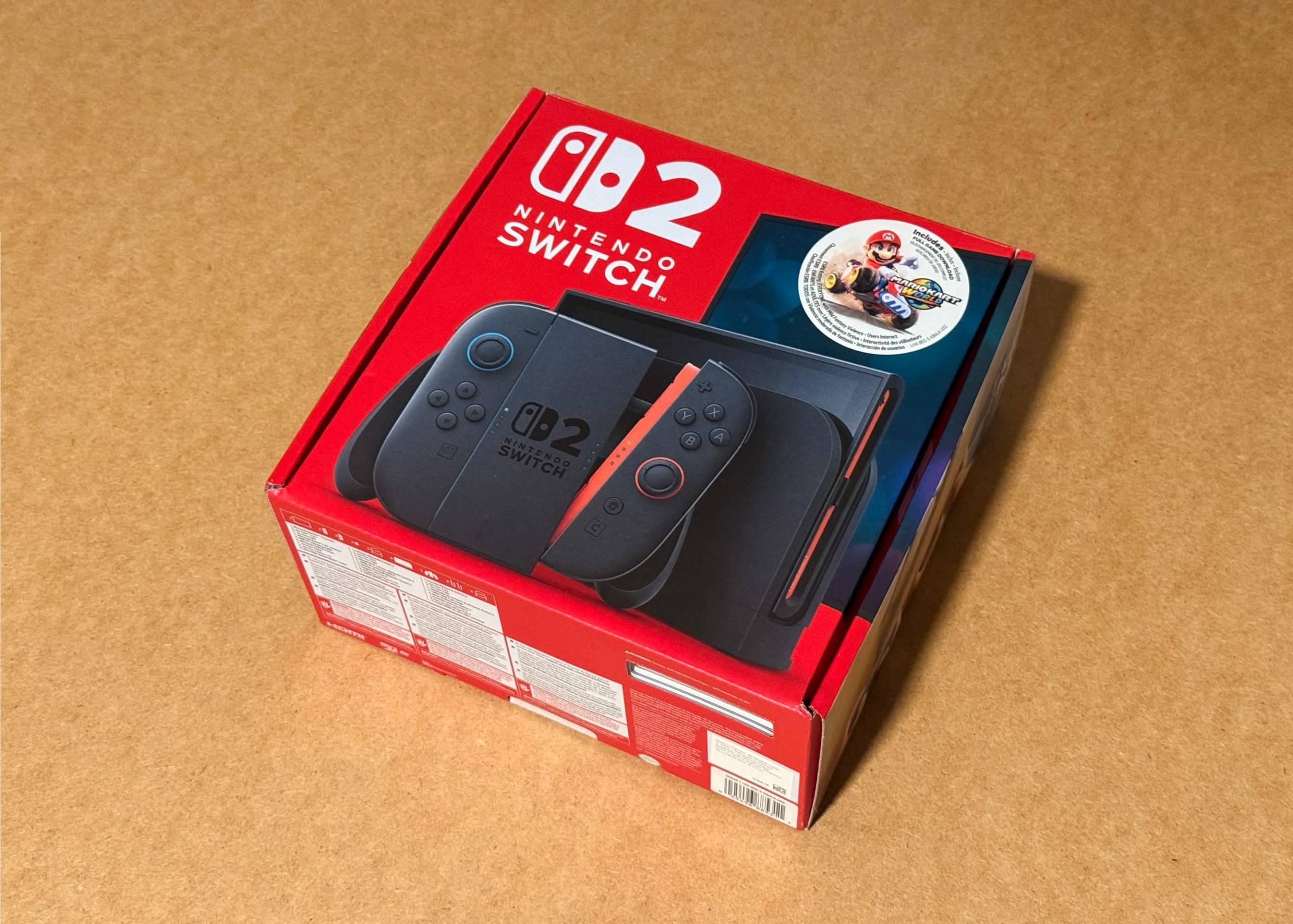 Red box containing the Nintendo Switch 2 console with controllers and game disc on top.