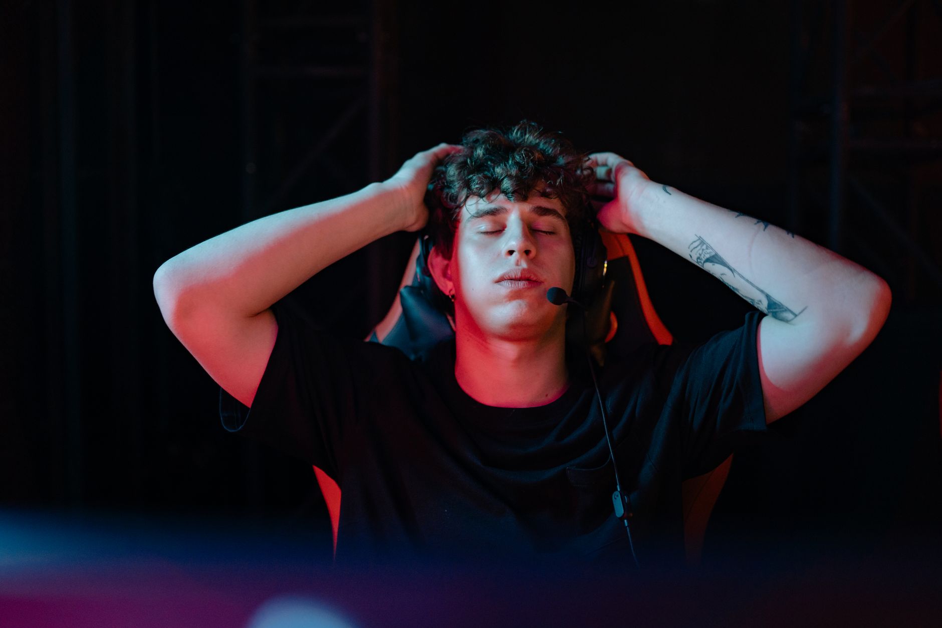 a tattooed man in a black shirt taking a deep breath