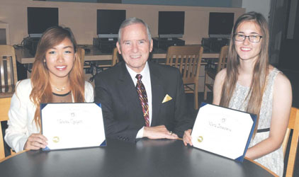 Superintendent of Schools Frederick F. Foresteire presents Certificates of Academic Excellence to Vanessa Nguyen and Vesna Imsirovic.