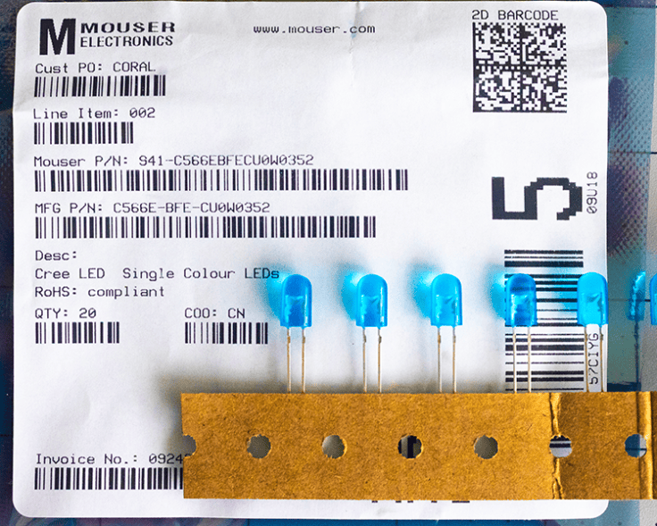A label from Mouser Electronics showcasing a product order, featuring details like item number, description of Cree single color LEDs, and a quantity of 20, alongside several blue LEDs attached to a brown card.