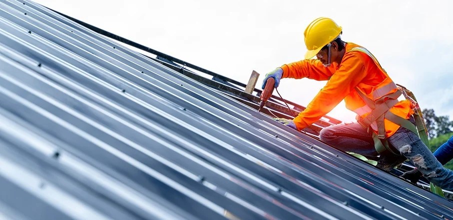 Close-up of professional roofer securing shingles with tools.