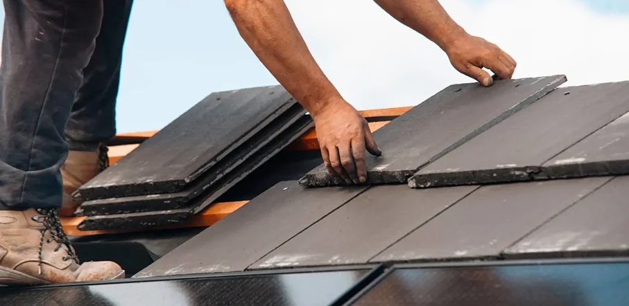 Crew of roofing contractors installing new shingles on a home.