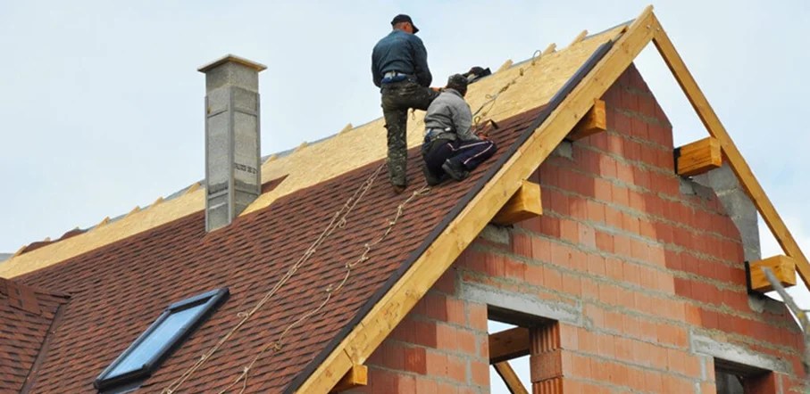 Roofers checking damage in a home after a storm.