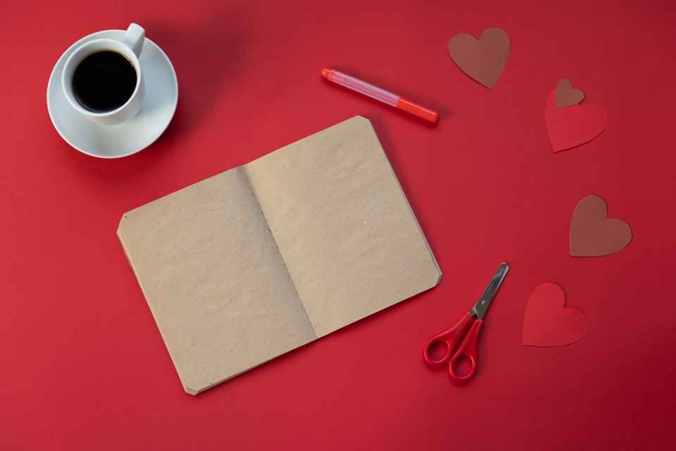 empty notepad near coffee and paper hearts