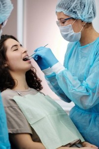 a dentist checking the woman s teeth a dentist checking the woman s teeth