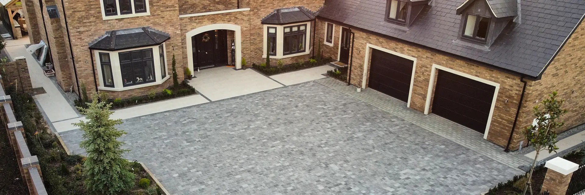 Drone shot of a large house with a large block paved driveway