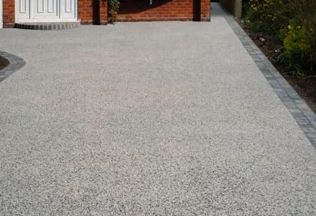 resin bound driveway leading to a red brick house.